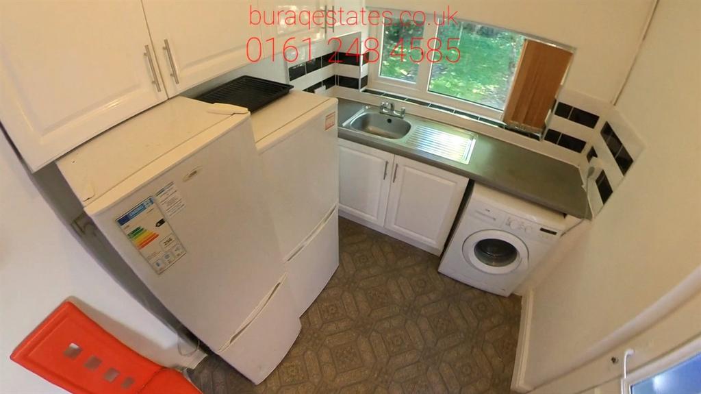 Compact, well-kept kitchen with white cabinets,...