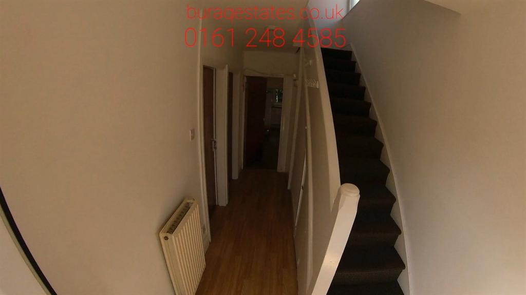 Narrow interior hallway with wooden flooring, a...