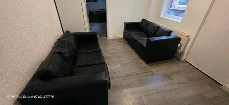 Bright communal lounge with matching black sofa...