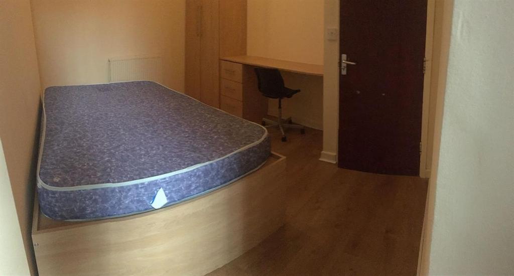 Neat, simply furnished bedroom with a single be...