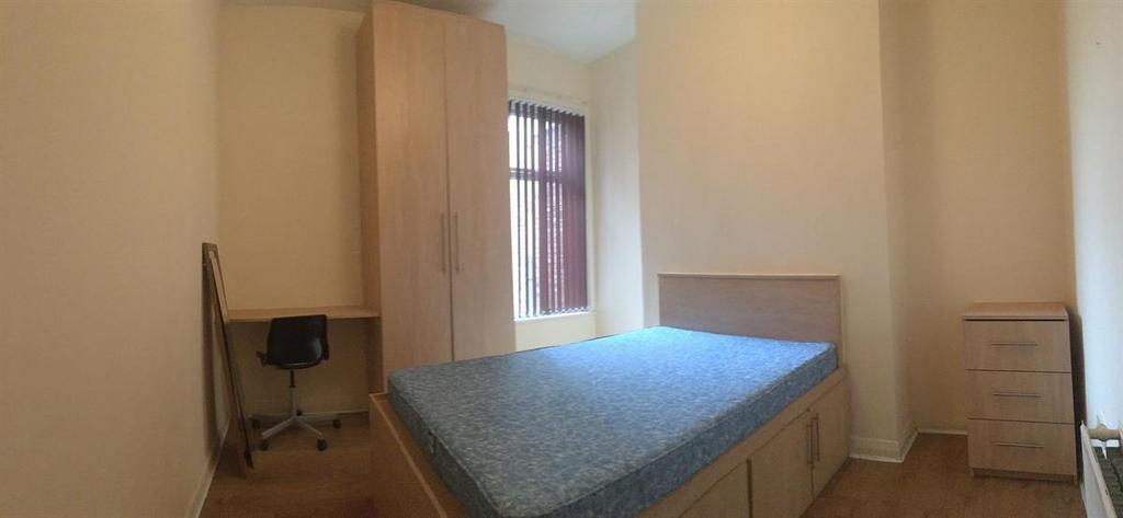 Bright, simply furnished bedroom with a single ...