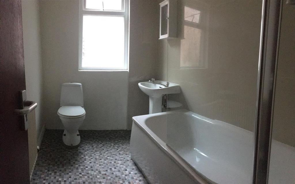Bright, clean bathroom with a white bathtub, pe...