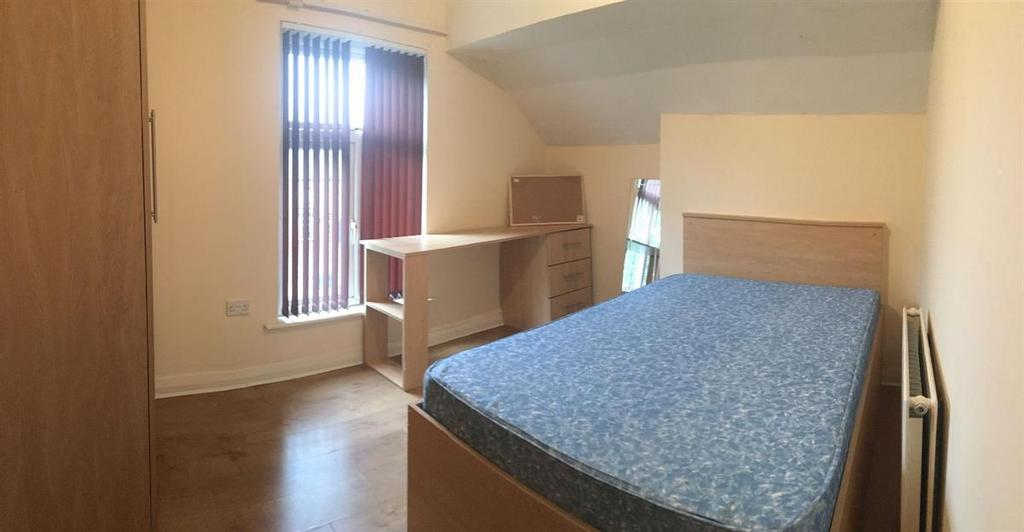 Bright, simply furnished bedroom with a double ...
