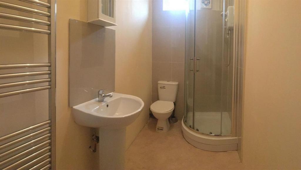 Bright, clean bathroom with a modern corner sho...