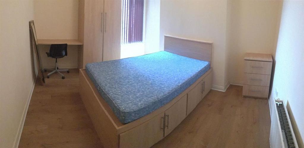 Bright, simply furnished bedroom with a built-i...