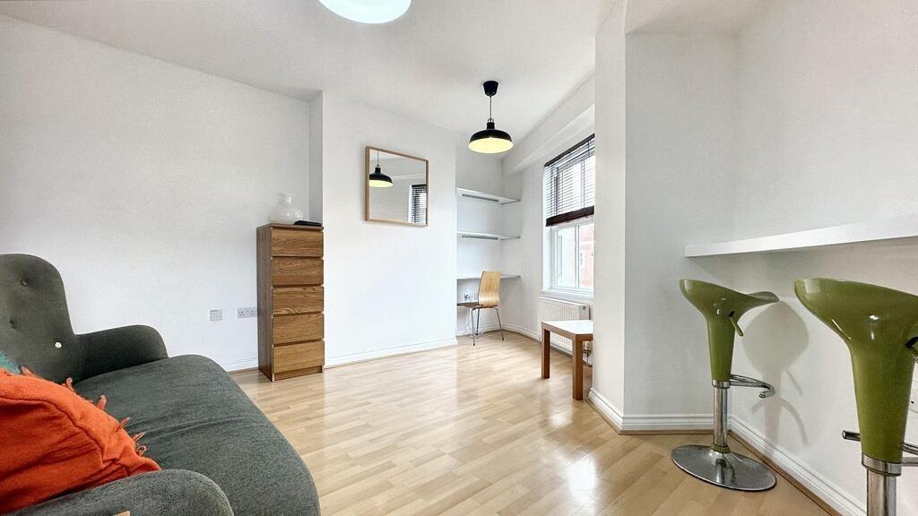 Bright, modern living area with light wood floo...