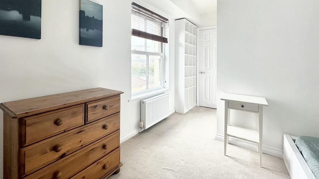 Bright, neutral double bedroom with large sash ...