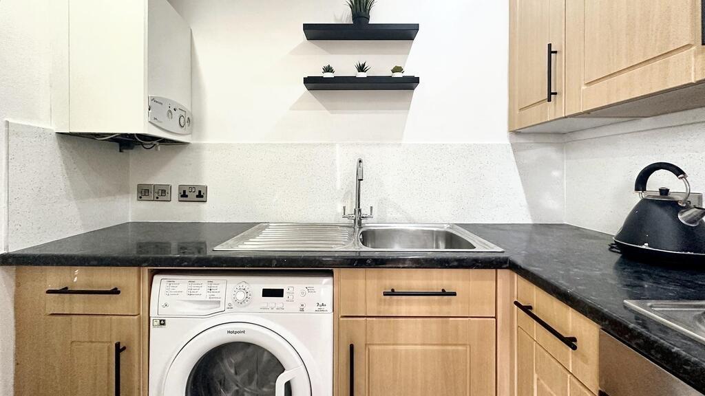 Modern fitted kitchen with light wood cabinetry...
