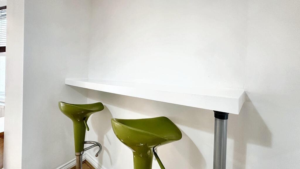 Bright white kitchenette-style breakfast bar wi...