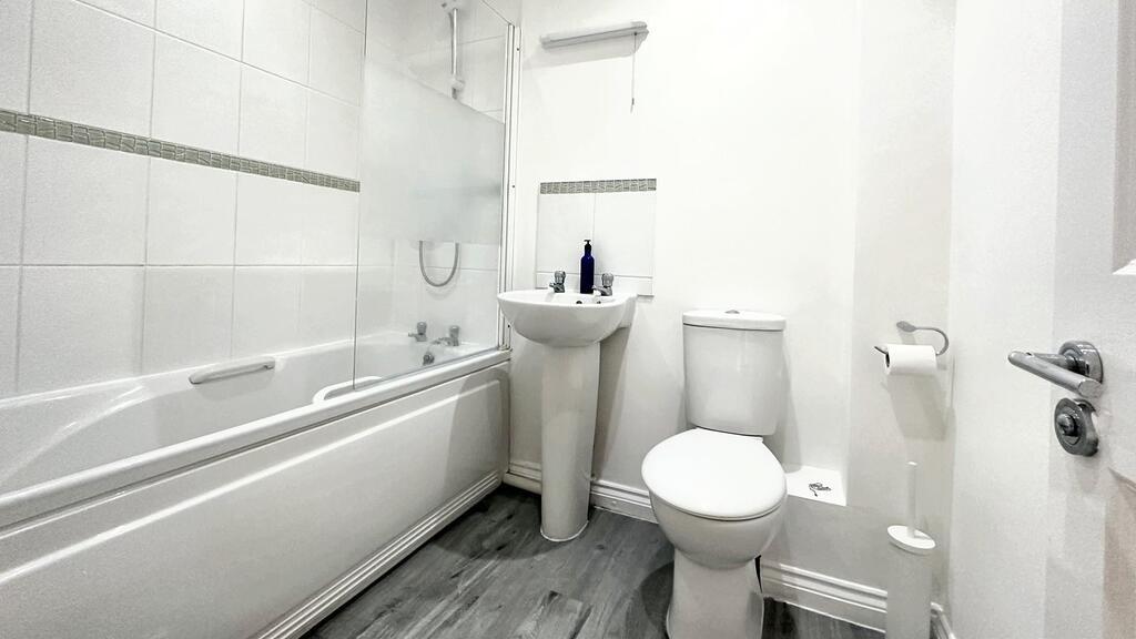 Bright, modern bathroom with a full-size bathtu...