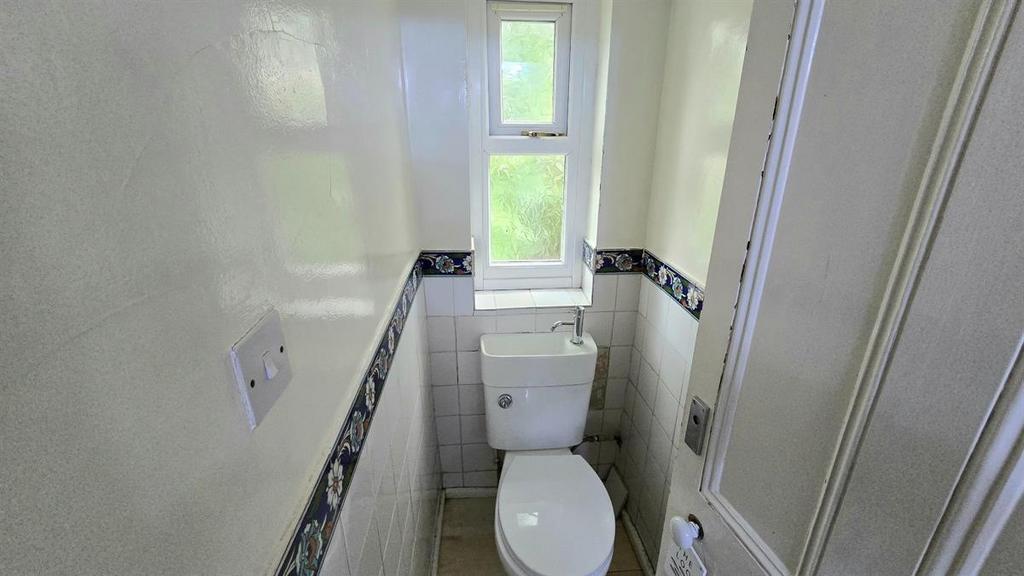 Compact, well-maintained WC with a white toilet...
