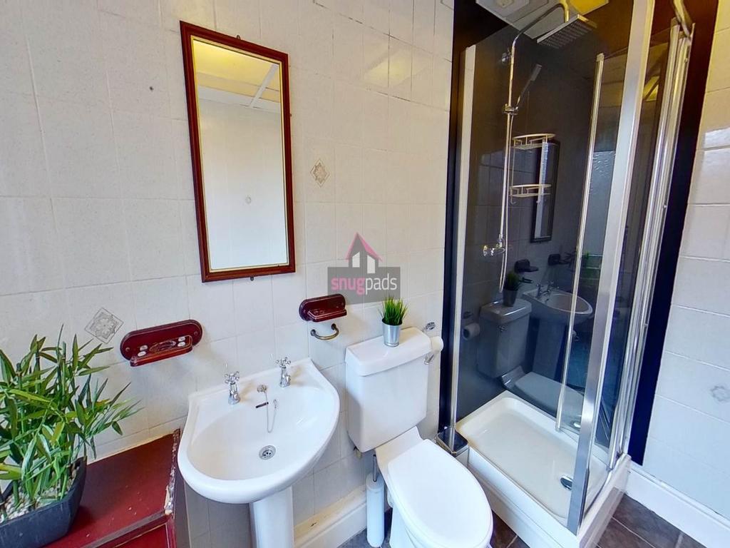 Clean, modern bathroom with a corner shower enc...