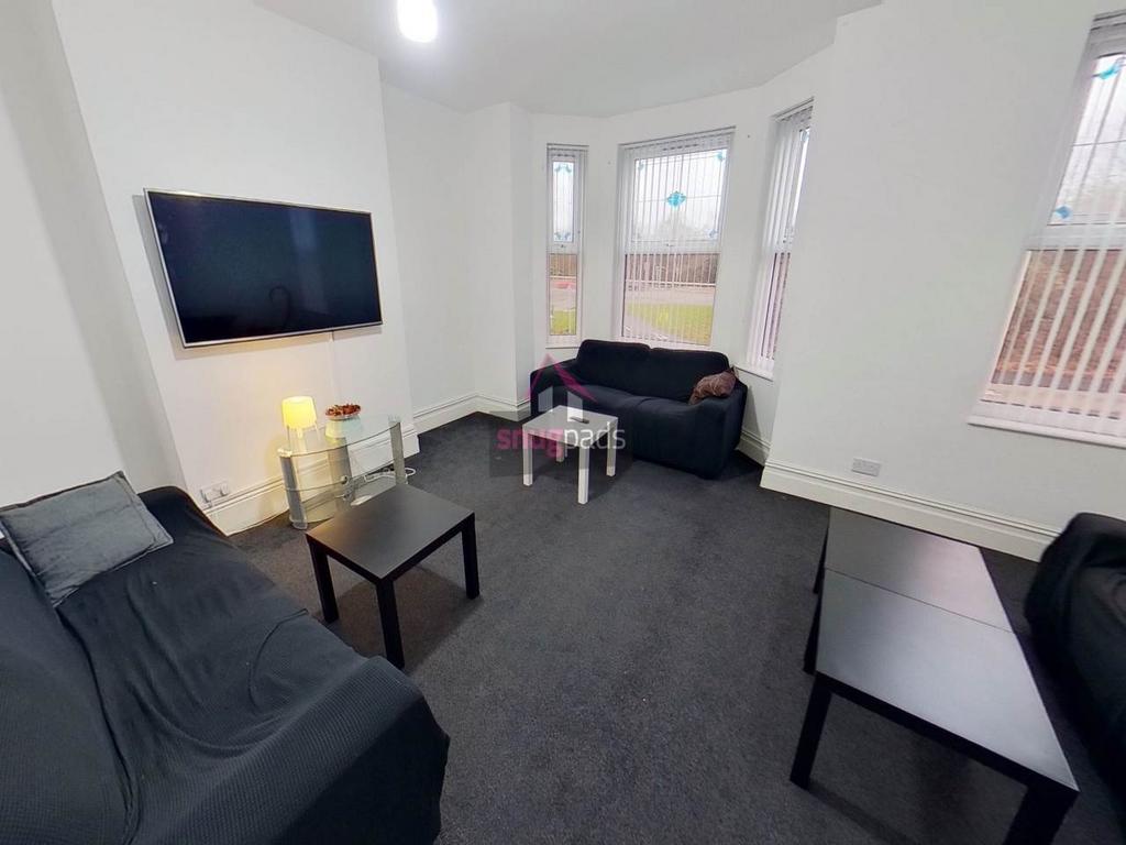 Bright communal lounge with multiple sofas, wal...