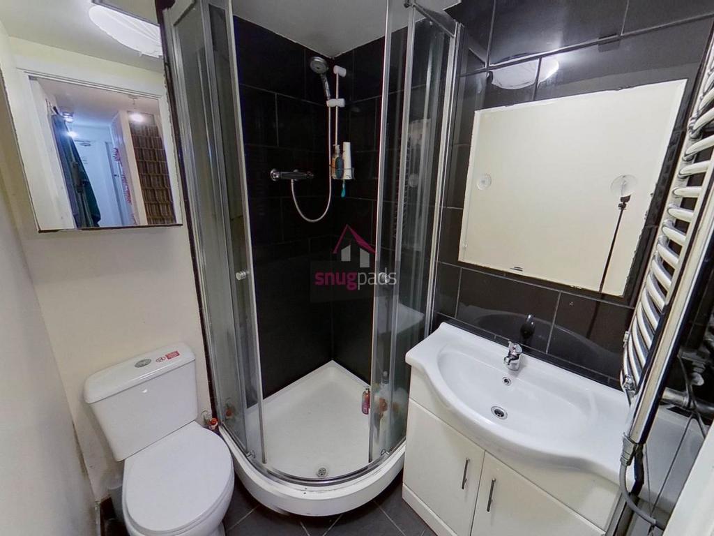 Modern bathroom with a corner glass shower encl...