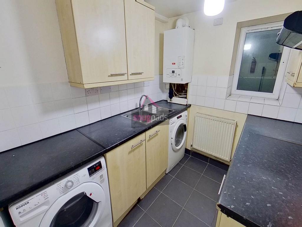 Compact galley kitchen with matching cabinets, ...