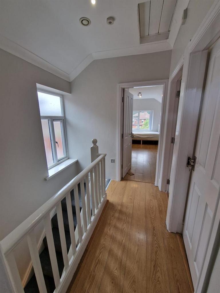 Bright upstairs landing with wood-effect floori...