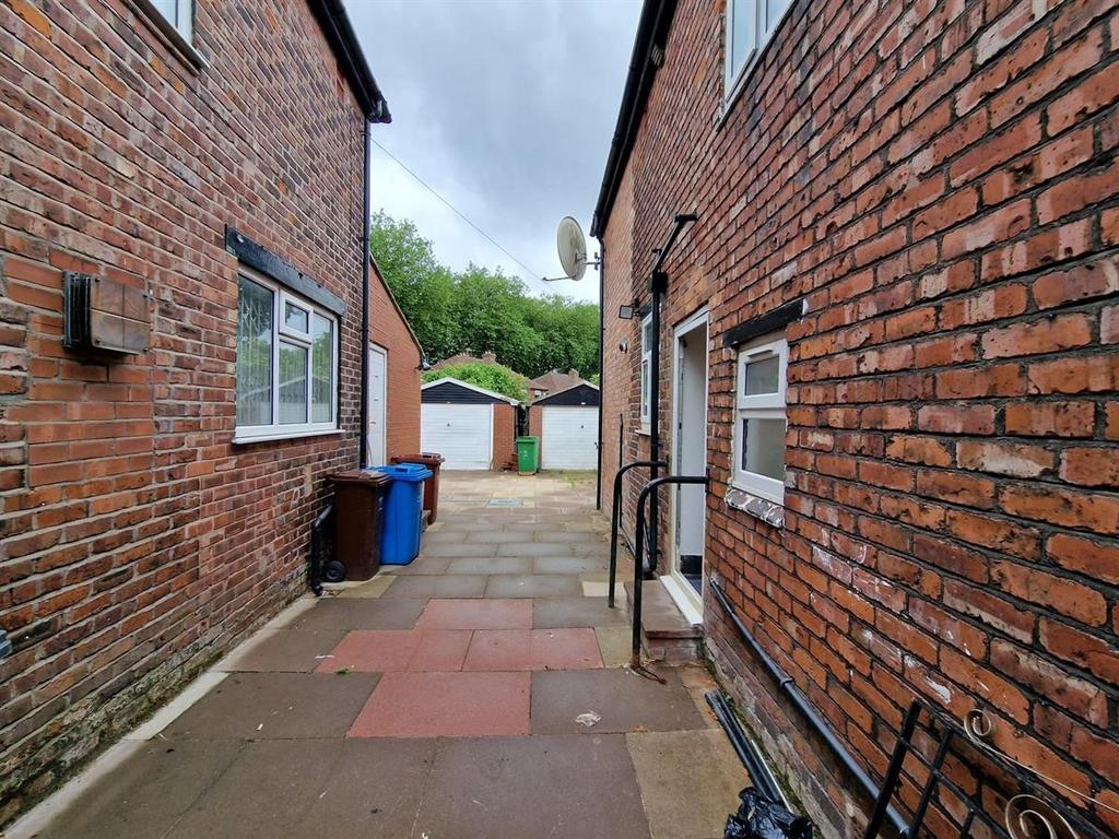 Narrow paved alleyway between two brick buildin...