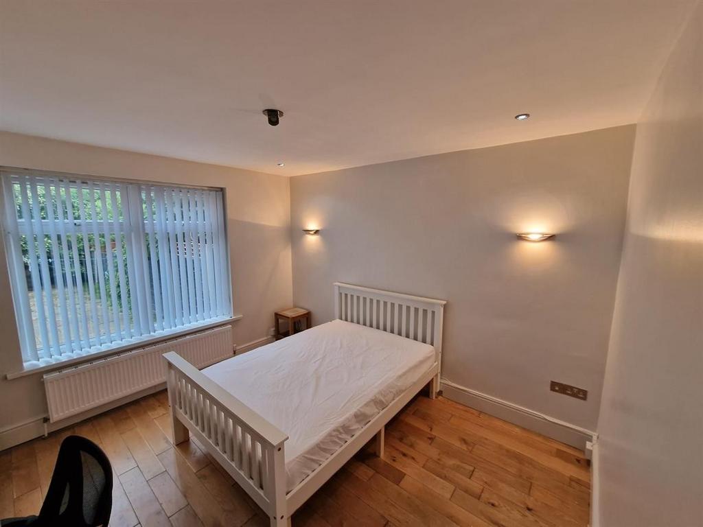 Bright, simple bedroom with a white wooden doub...