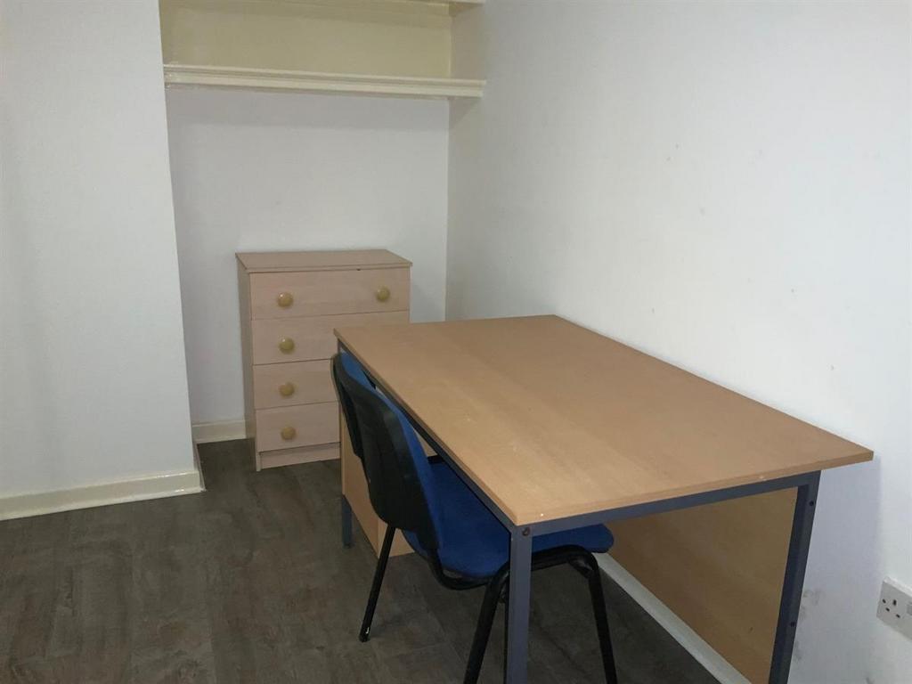 Simple, tidy single bedroom with a desk for stu...