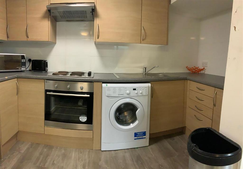 Neat modern kitchen with integrated oven, hob a...