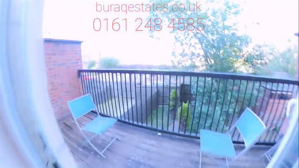 Sunny small balcony with a wooden deck, metal r...