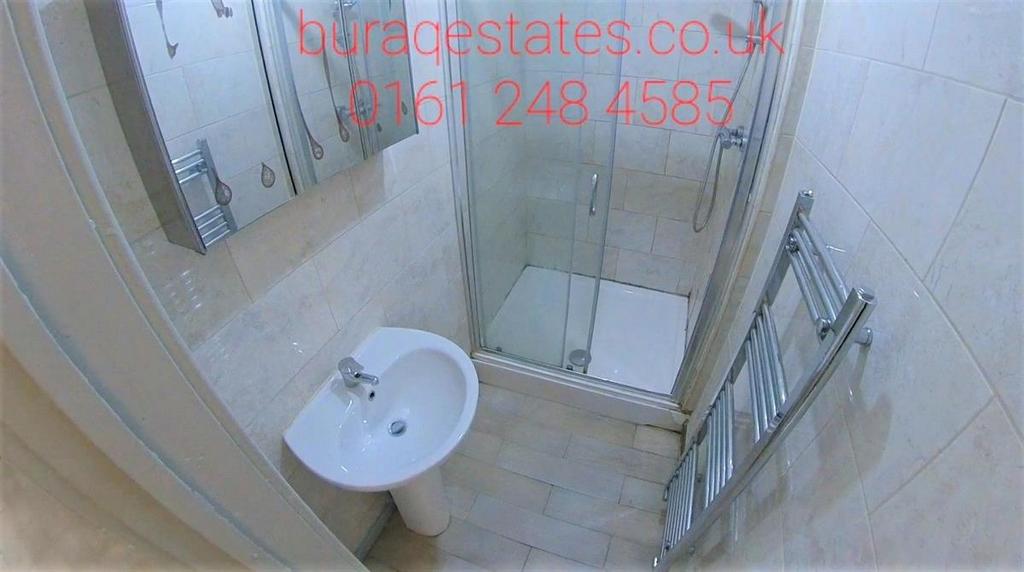Clean modern bathroom with a glass-enclosed sho...
