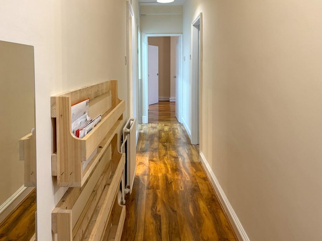 Bright, well-maintained hallway with warm wood-...