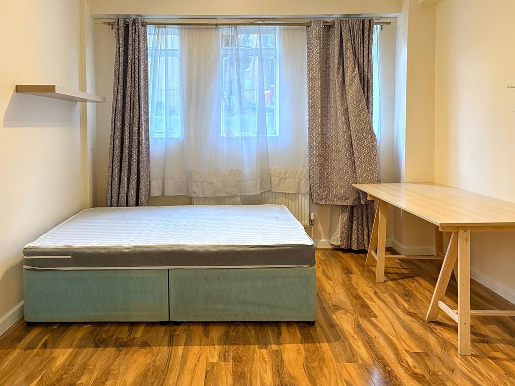 Bright, simply furnished bedroom with a double ...