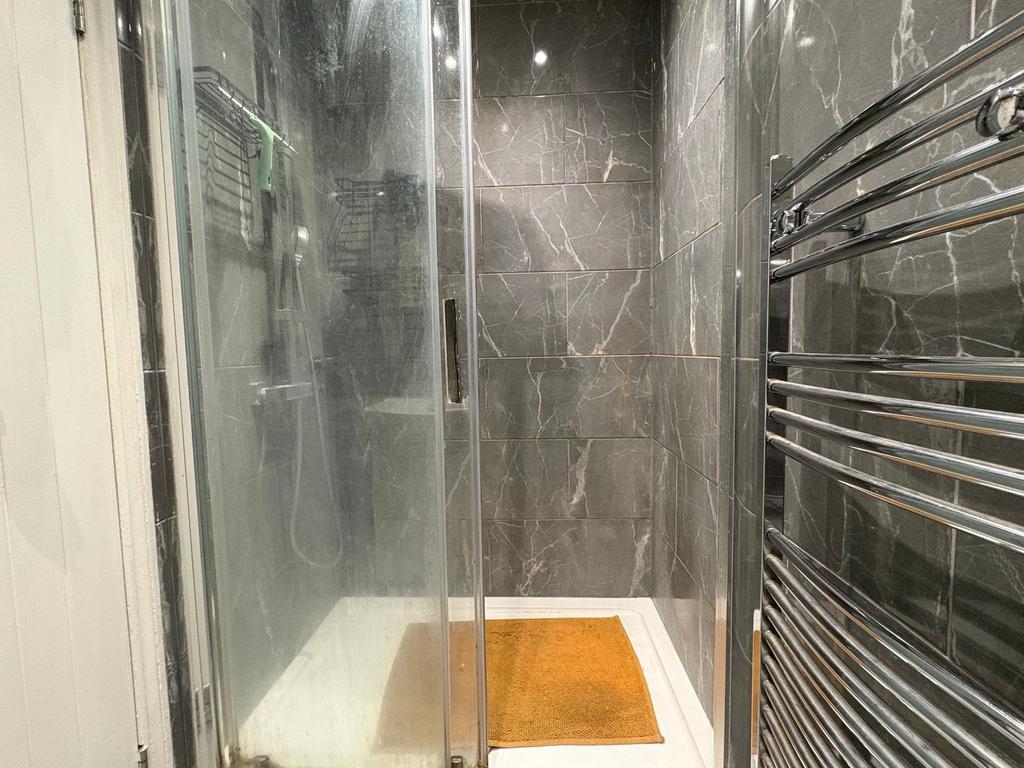 Modern shower enclosure with dark marble-effect...