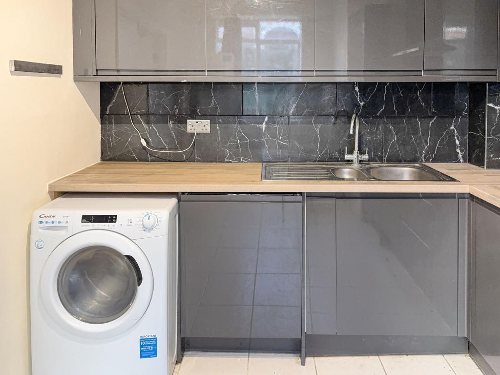 Modern kitchen area with a double stainless ste...