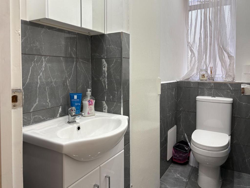 Clean, modern bathroom with grey marble-effect ...