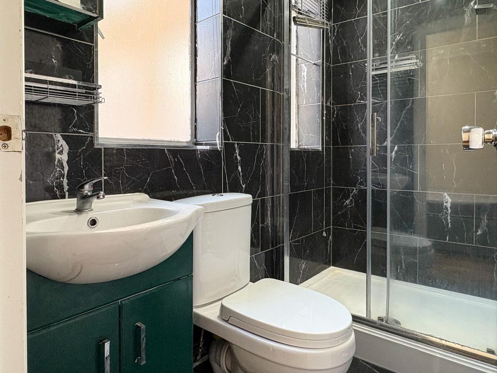 Modern bathroom with black marble-effect tiled ...