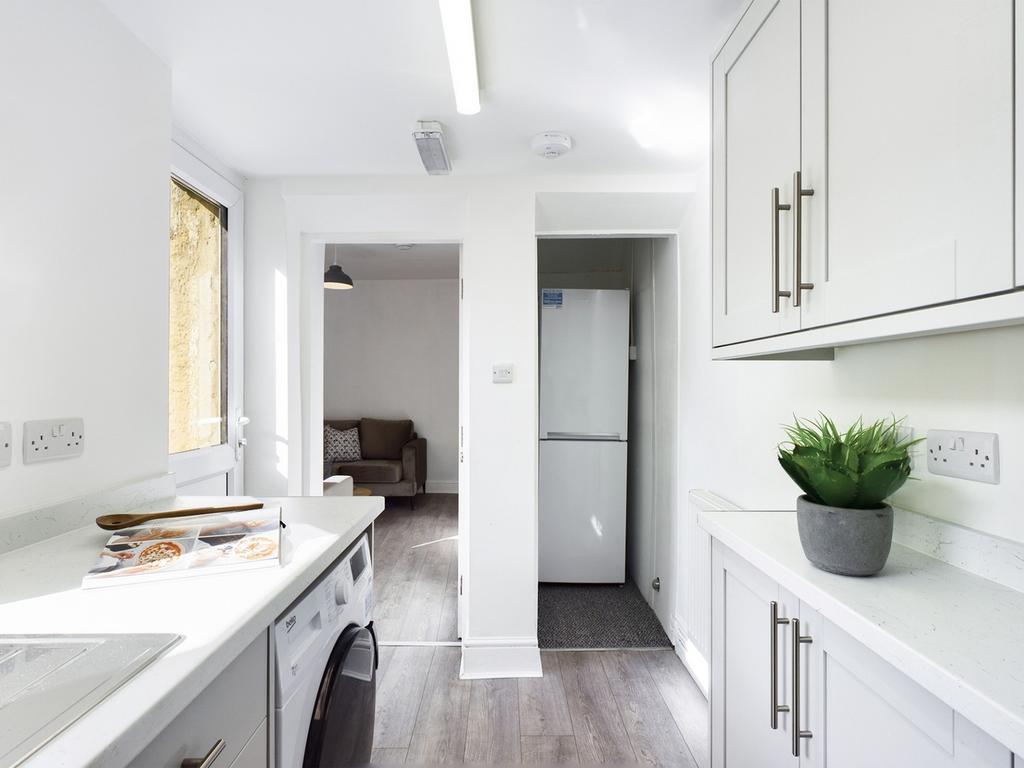 A bright and modern kitchenette with clean surf...