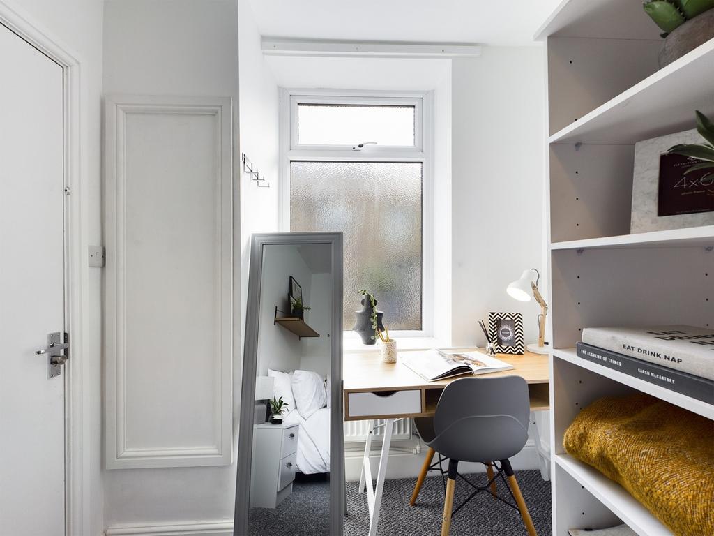 A bright and tidy study area with a desk and mo...