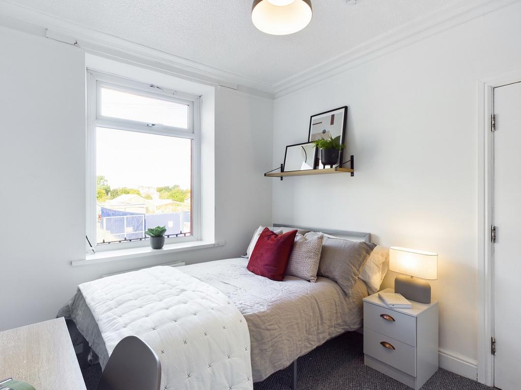 A bright and inviting double bedroom with moder...