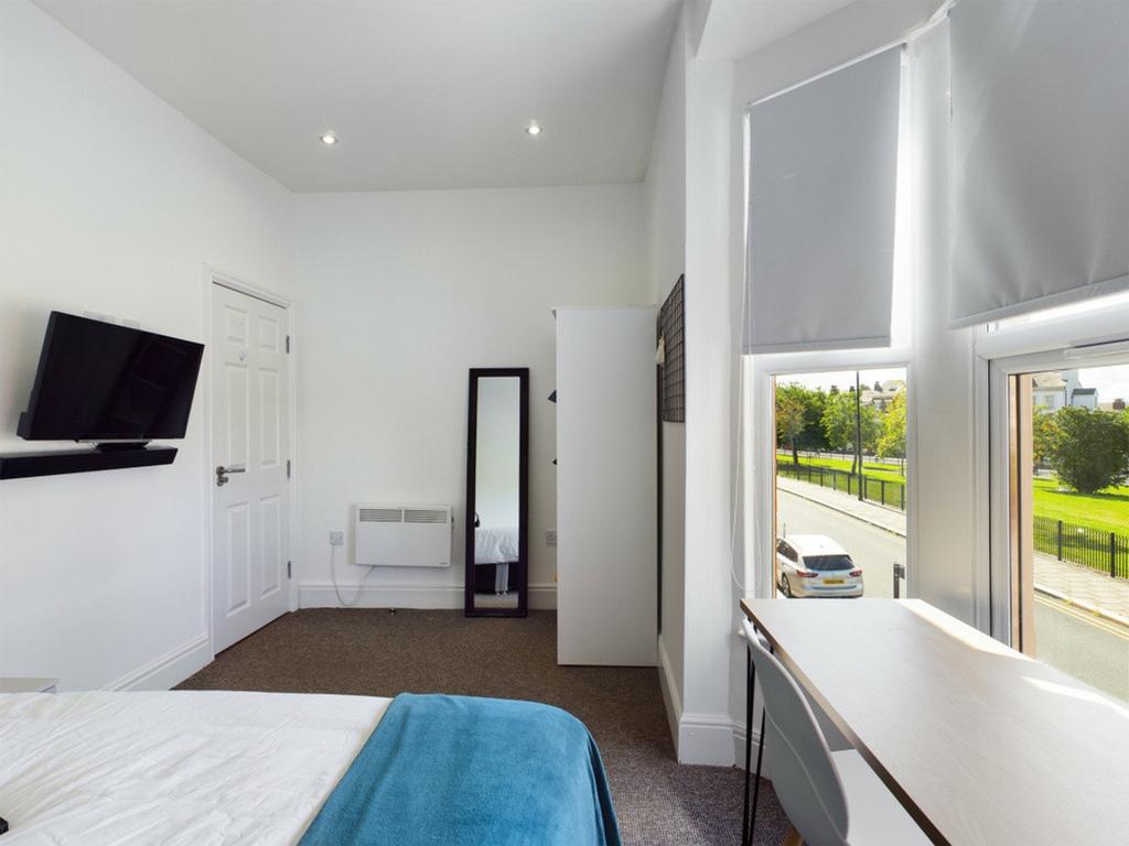 A bright and spacious double bedroom with moder...