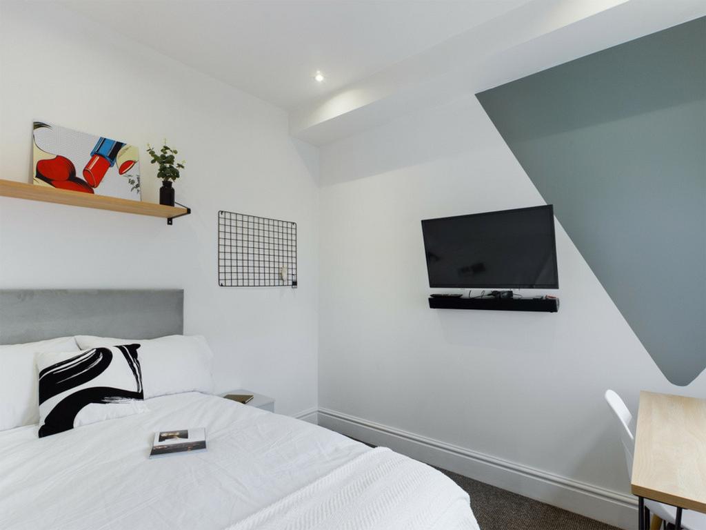 A bright and modern double bedroom featuring st...