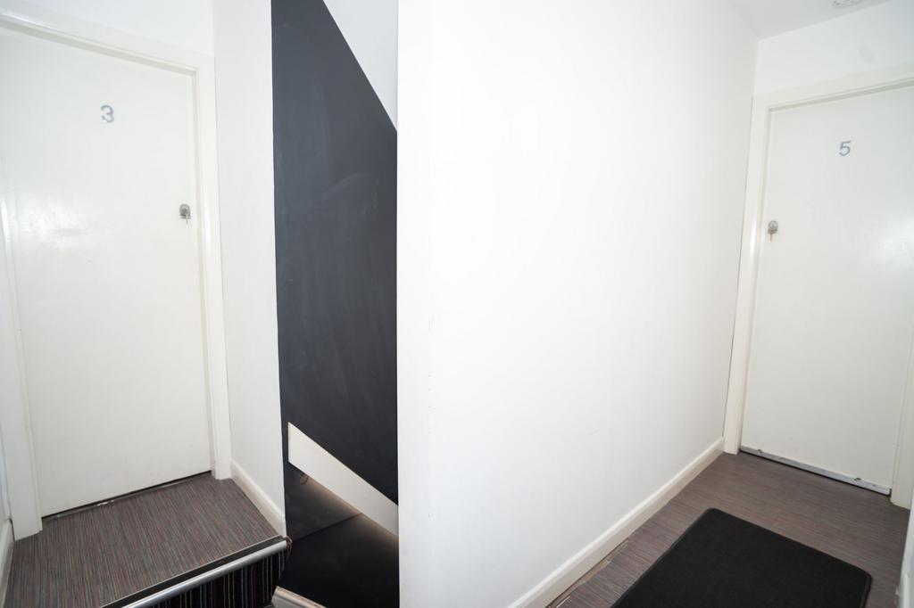 Bright, clean communal hallway with numbered do...