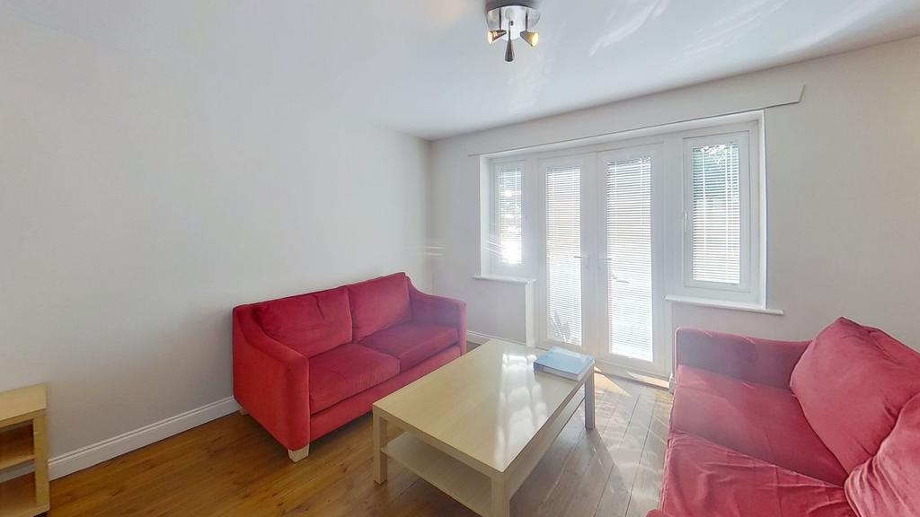 Bright, tidy living room with matching red sofa...