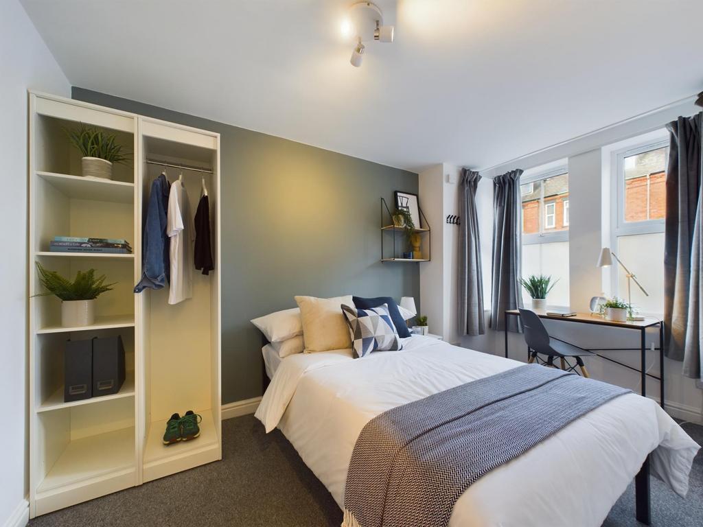 A bright and comfortable bedroom featuring a ne...