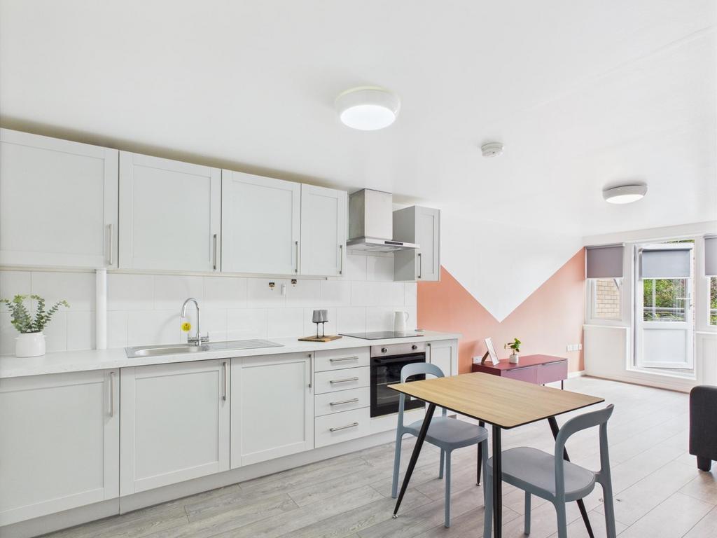 Bright modern open-plan kitchen with white cabi...