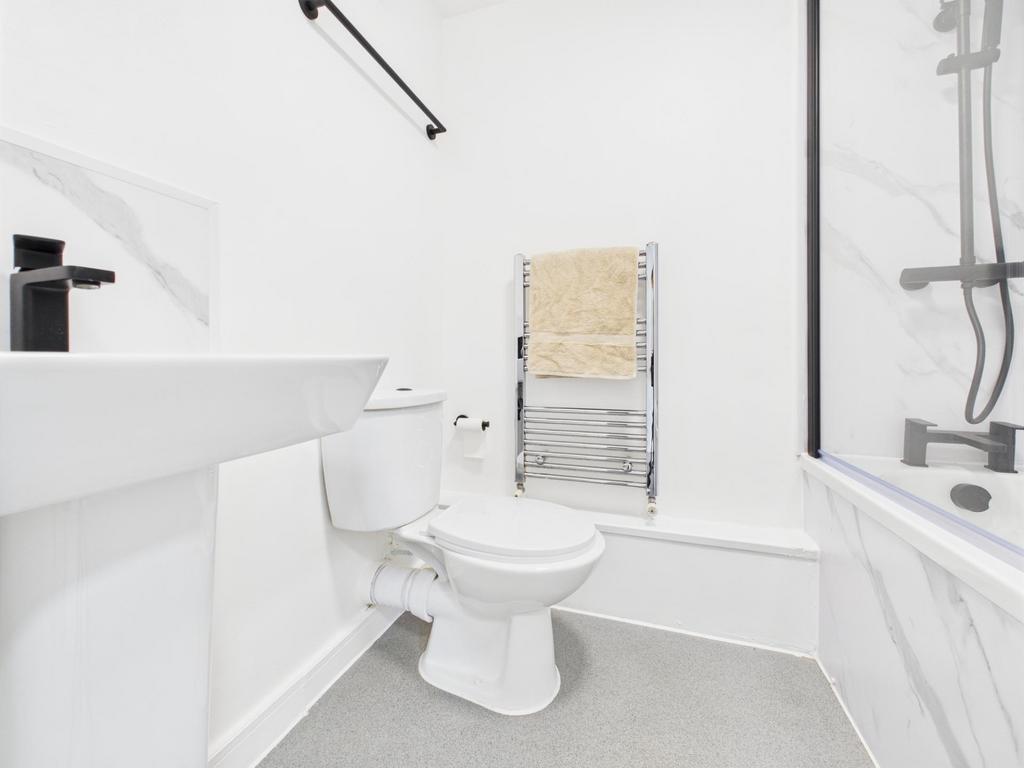 Bright, modern bathroom with a white suite, bat...