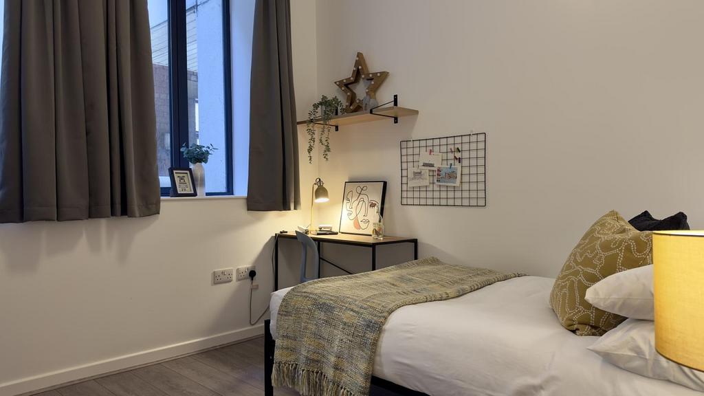 A bright and tidy double bedroom featuring mode...