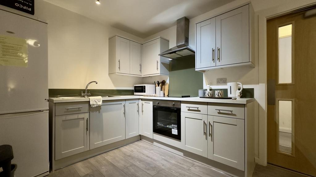 A bright and modern kitchenette with ample stor...