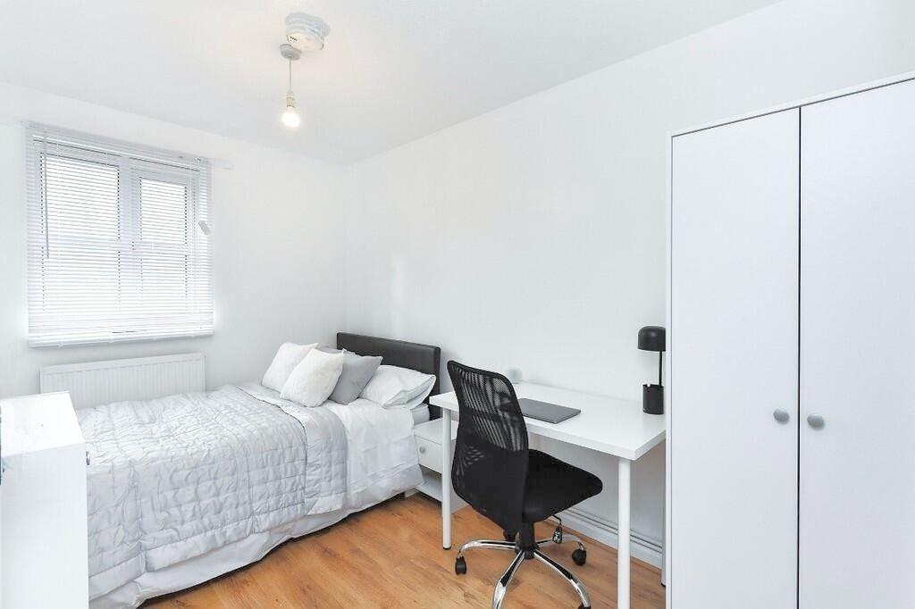 Bright and tidy bedroom featuring a comfortable...