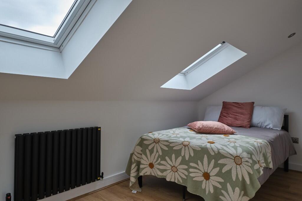 A bright and welcoming bedroom featuring a larg...