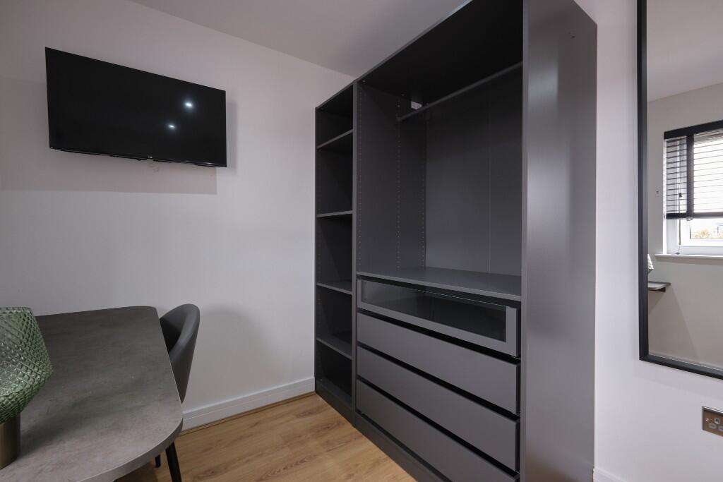 Modern bedroom area with built-in dark grey war...