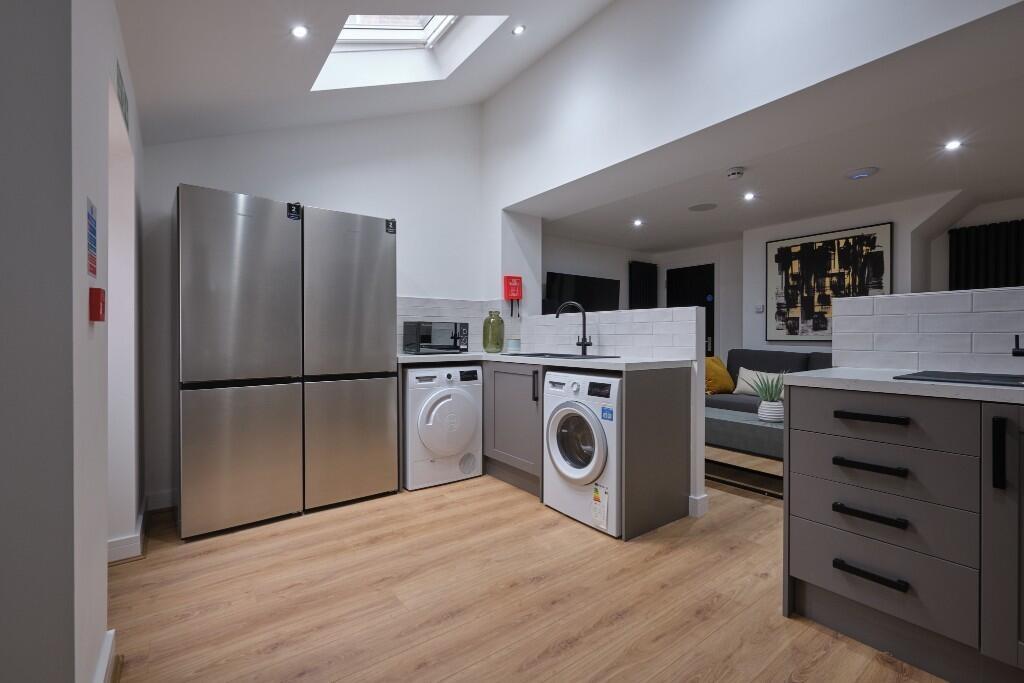 Modern open-plan kitchen with integrated applia...