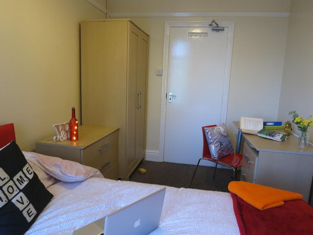 Bright, neatly furnished single bedroom with a ...