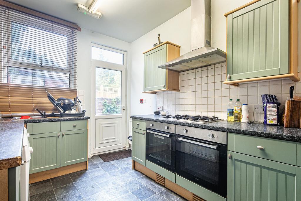 Bright galley kitchen with twin built-in ovens,...